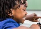 Smiling boy using digital tablet in classroom